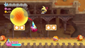 Kirby bombs a Sir Kibble while maneuvering along one of the sand conveyor belts.
