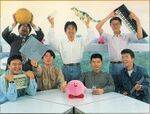 Picture of the staff who worked on Kirby's Dream Course. Hirokazu Ando is seen holding a Yamaha DX100.