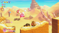 Invincible Kirby kicks a Waddle Doo out of the way while dashing along the dunes in Kirby's Return to Dream Land Deluxe