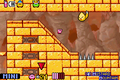 Mini Kirby sliding past a narrow passageway in a different part of Mustard Mountain