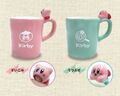 Two pink and blue ceramic mugs with Kirby figurines on the handle